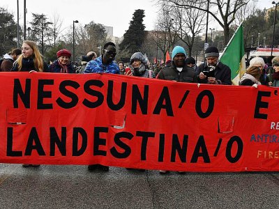 Une affiche "Personne n'est clandestin" lors d'une marche contre le racisme à Macerata, dans le centre de l'Italie, le 10 février 2018 - TIZIANA FABI [AFP]