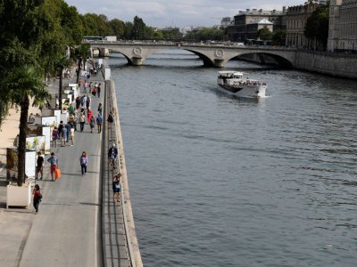 Des Parisiens se promènent au bord de la Seine, le 11 septembre 2016 - MIGUEL MEDINA [AFP/Archives]