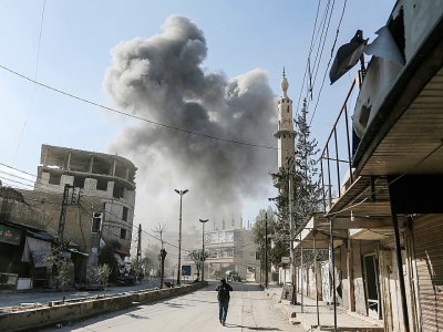 De la fumée s'élève au-dessus d'un bâtiment après des bombardements sur la ville de Hamouria, dans l'enclave rebelle de la Ghouta orientale, près de Damas le 21 février 2018 - ABDULMONAM EASSA [AFP]
