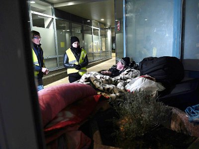 Des volontaires des Restos du Coeur parlent avec un sans-abri à Strasbourg, où la température est descendue à -7 degrés en soirée le 26 février 2018 - FREDERICK FLORIN [AFP]