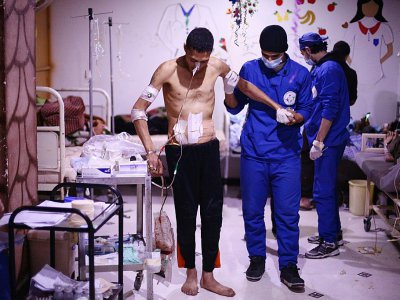 Des médecins syriens assistent des blessés dans un hôpital de fortune, le 25 février 2018 dans la Ghouta orientale - AMER ALMOHIBANY [AFP]