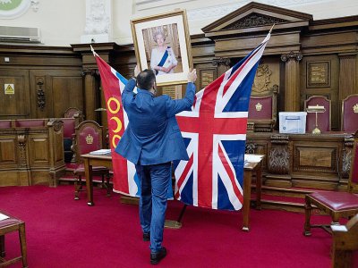 L'officier d'Etat civil d'Islington, Dion Goncalves, installe un portrait de la reine Elizabeth II avant une cérémonie d'allégeance de nouveaux citoyens britanniques, le 5 février 2018 - JUSTIN TALLIS [AFP]