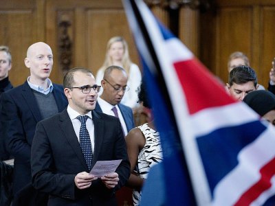 Des nouveaux citoyens britanniques chantent l'hymne national lors d'une cérémonie d'allégeance à la reine Elizabeth II, le 5 février 2018 à la mairie d'Islington, dans le nord de Londres - JUSTIN TALLIS [AFP]