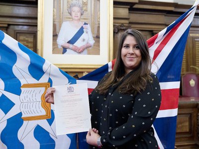 Une femme, nouvelle citoyenne britannique, montre son certificat de naturalisation, après une cérémonie d'allégeance à la reine Elizabeth II, le 5 février 2018 à Islington, dans le nord de Londres - JUSTIN TALLIS [AFP]