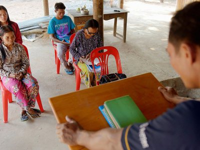 Im Chaem (2e d) ancienne cadre du régime Khmer rouge assiste à un prêche et lit la Bible dans une église de fortune, le 25 février 2018 à Anlong Veng - TANG CHHIN SOTHY [AFP]