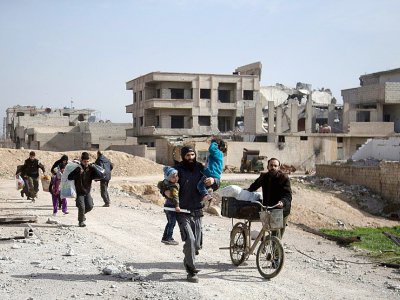 Des civils fuient la ville de Beit Sawa, en Ghouta orientale, à l'est de Damas, le 4 mars 2018 - ABDULMONAM EASSA [AFP]