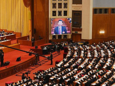 Le président chinois Xi Jinping apparait en direct sur un écran au dessus des délégués pendant le discours du Premier ministre Li Keqiang lors de l'ouverture de la session annuelle du Parlement, à Pékin le 5 mars 2018 - GREG BAKER [AFP]