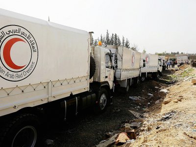 Des véhicules transportant des aides à destination de la Ghouta orientale assiégée au point de passage d'al-Wafidin en périphérie de Damas,  le 5 mars 2018 - Louai Beshara [AFP]