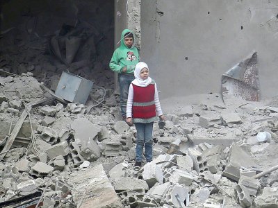 Des enfants syriens au milieu des destructions à Hammouriyé dans la partie rebelle de la Ghouta orientale, bombardée par le régime, le 22 février 2018 - ABDULMONAM EASSA [AFP]