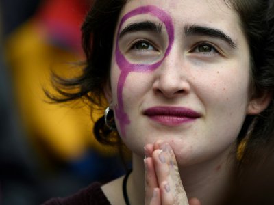 Une femme maquillée avec le symbole de Venus lors d'une manifestation à Barcelone le 8 mars 2018 pour célébrer la journée internationale des droits des femmes - LLUIS GENE [AFP]