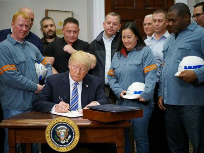 Donald Trump signant les taxes sur les importations d'acier et d'aluminium aux côtés de travailleurs du secteur à la Maison Blanche le 8 mars 2018 - MANDEL NGAN [AFP]