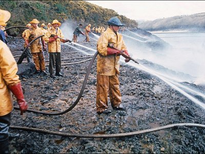 Des équipes de nettoyage luttent contre la pollution qui a frappé le littoral breton à la suite du naufrage du pétrolier Amoco Cadiz face au port de Portsall, dans le Finistère, le 16 mars 1978 - JEAN-PIERRE PREVEL [AFP/Archives]