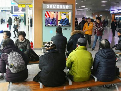 Des personnes regardent un téléviseur montrant des photographies du président américain Donald Trump (G) et du dirigeant nord-coréen Kim Jong Un dans une gare de Séoul, le 9 mars 2018 - Jung Yeon-je [AFP]