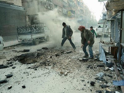 Des hommes constatent les dégâts après un bombardement du régime sur Douma, la principale ville de l'enclave rebelle dans la Ghouta orientae, le 10 mars 2018 - HAMZA AL-AJWEH [AFP]