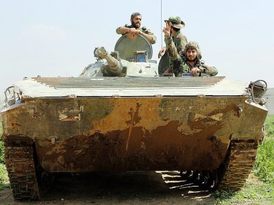 Des membres des forces progouvernementales syriennes dans un tank, le 10 mars 2018 à Aftris, dans la Ghouta orientale - STRINGER [AFP]