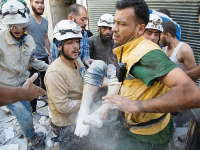 Les "casques blancs" syriens transportent un corps après un raid aérien à Alep le 23 juillet 2016 - KARAM AL-MASRI [AFP/Archives]