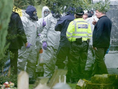 Des membres des services d'urgence portent des combinaisons de protection , le 10 mars 2018, dans un cimetière de Salisbury, dans le sud de l'Angleterre où sont enterrés la femme et le fils de l'ancien agent russe Sergueï Skripal, empoisonné avec sa - Daniel LEAL-OLIVAS [AFP]