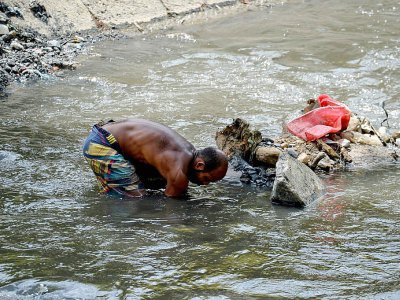Au péril de leur vie, des Vénézuélien fouillent les eaux sales du fleuve Guaire, le 1er février 2018 - FEDERICO PARRA [AFP/Archives]