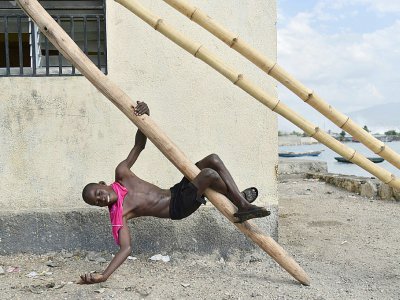 Un jeune garçon joue près du quai de Cité Soleil, une des plus pauvres de Haïti, située sur la baie de Port-au-Prince, le 14 mars 2018 - Hector RETAMAL [AFP/Archives]