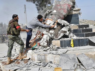 Des rebelles syriens pro-turcs déboulonnent une statue kurde dans le centre de la ville d'Afrine (nord-ouest de la Syrie), le 18 mars 2018 - Bulent Kilic [AFP]