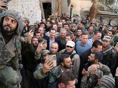 Photo distribuée par la présidence syrienne montrant Bachar al-Assad au milieu de soldats lors de sa visite dans la Ghouta orientale, près de Damas, le 18 mars 2018 - HO [Syrian Presidency Facebook page/AFP]