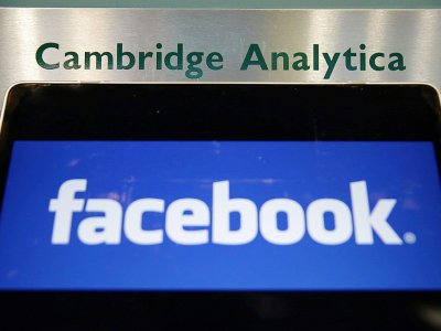 Le logo de Facebook affiché sur un ordinateur portable devant la plaque d'entrée de la société britannique Cambridge Analytica à Londres, le 21 mars 2018 - Daniel LEAL-OLIVAS [AFP]