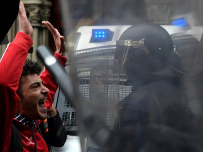 Un manifestant à Barcelone le 25 mars 2018 qui proteste contre l'arrestation de Carles Puigdemont en Allemagne à la demande de la justice espagnole, face à la police anti-émeutes - LLUIS GENE [AFP]