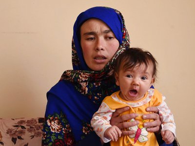 Jahantab Ahmadi, une Afghane déterminée à faire des études dont la photo a ému tout le pays, avec son plus jeune enfant lors d'un entretien avec l'AFP à Kaboul, 24 mars 2018 - WAKIL KOHSAR [AFP]