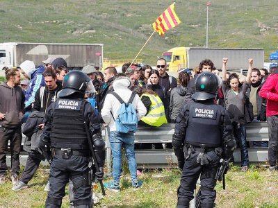 Des policiers font face à des séparatistes catalans qui bloquent une route, le 27 mars 2018 près de Figueras, en Espagne - RAYMOND ROIG [AFP]