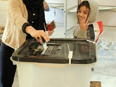 Une Egyptienne met son bulletin dans l'urne lors de la troisième et dernière journée du scrutin présidentiel, le 28 mars 2018 dans un quartier d'Alexandrie (nord) - STRINGER [AFP]