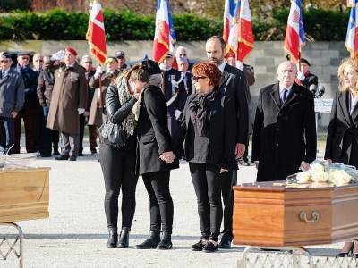 Edouard Philippe, Gérard Collomb et Nicole Belloubet se tiennent derrière des membres de la famille d'une des victimes des attentats de l'Aude lors d'un hommage solennel à Trèbes, le 29 mars 2018 - ERIC CABANIS [AFP]