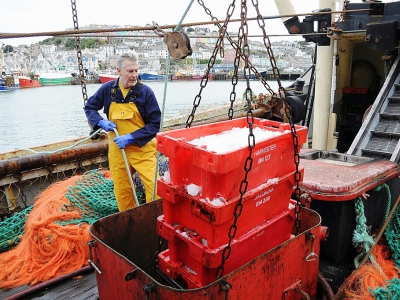 Un pêcheur avec des caisses de poissons fraîchement pêchés sur le chalutier Stephanie au port de Brixham dans le sud de l'Angleterre le 26 mars 2018 - Joe JACKSON [AFP]