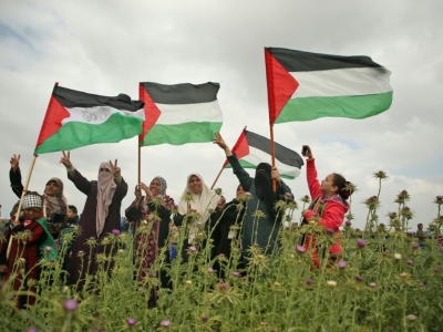 Des femmes brandissent des drapeaux palestiniens pendant une manifestation dans la bande de Gaza, près de la barrière de sécurité qui sépare l'enclave d'Israël, le 30 mars 2018 - Mohammed ABED [AFP]