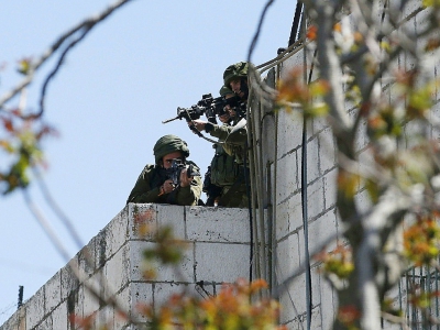 Des soldats israéliens braquent leurs armes vers des manifestants palestiniens, le 31 mars 2018 à Hébron, en Cisjordanie - HAZEM BADER [AFP]