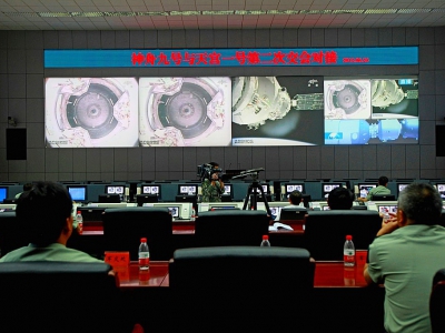 Sur cette image d'archive du 24 juin 2012, des techniciens chinois du Centre spatial de Jiuquan  suivent l'arrimage du vaisseau Shenzhou-9  à la station spatiale Tiangong-1. - STR [AFP/Archives]