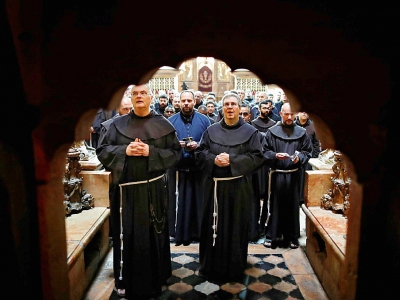 Des moines franciscains prient devant l'endroit où Jésus à été crucifié et mis au tombeau, selon la tradition, à l'intérieur de l'église du Saint Sépulcre à Jérusalem, le 23 février 2018 - Thomas COEX [AFP]