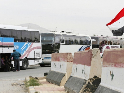Bus du gouvernement syrien stationnés au passage de Wafidine, en périphérie de Damas, dans l'attente de nouvelles évacuations de Douma des combattants rebelles et de leus famille, le 3 avril 2018 - Louai Beshara [AFP]
