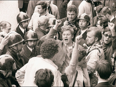 Daniel Cohn-Bendit (c-poing levé) chante "l'Internationale" le 6 mai 1968 à Paris, entouré des CRS et d'autres étudiants contestataires, avant de se rendre devant la commission de discipline de l'université de Paris-Sorbonne - [ARCHIVES/AFP/Archives]