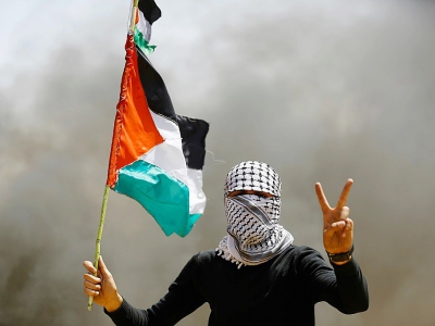 Un manifestant palestinien au visage recouvert par un keffieh lors d'une manifestation le 6 avril 2018 près de la frontière entre la bande de Gaza et Israël - MOHAMMED ABED [AFP]