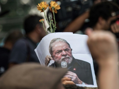 Un partisan de Lula arbore une photo de l'ex-président le 7 avril 2018 au cours d'une messe à la mémoire de son épouse. - NELSON ALMEIDA [AFP]