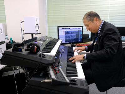 Le compositeur Minoru Mukaiya sur son piano, à son domicile de Tokyo, le 1er mars 2018 - Kazuhiro NOGI [AFP]