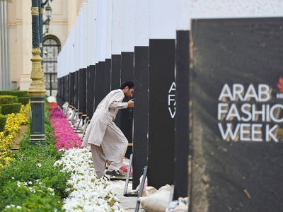 Un employé installe des panneaux annonçant la première fashion week en Arabie Saoudite, le 10 avril 2018 à Ryad - FAYEZ NURELDINE [AFP]