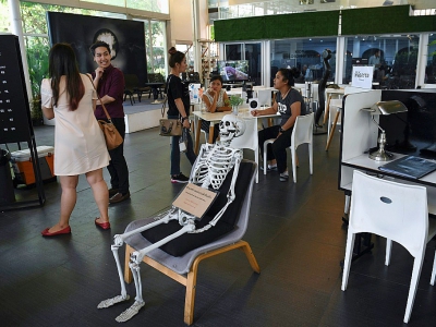 Un squelette trône au milieu du "café de la mort", à Bangkok, le 5 avril 2018 - LILLIAN SUWANRUMPHA [AFP]