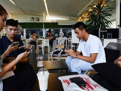 Des clients boivent au "café de la mort", à Bangkok, le 5 avril 2018 - LILLIAN SUWANRUMPHA [AFP]