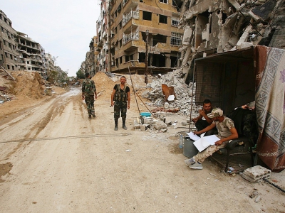 Des soldats syriens devant des immeubles détruits à Douma, le 11 avril 2018 - Youssef KARWASHAN [AFP]