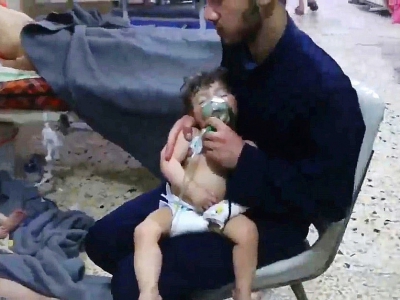 Une image capturée sur une vidéo diffusée par les secouristes syriens en zones rebelles, les Casques blancs, montrant un enfant victime d'une attaque chimique présumée soigné dans un hôpital improvisé de Douma le 8 avril 2018 - HO [AFP/Archives]