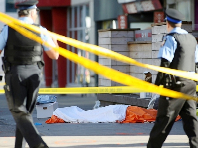 Des policiers à côté du corps d'une des victimes renversées par une camionnette le 23 avril 2018 à Toronto - Lars Hagberg [AFP]