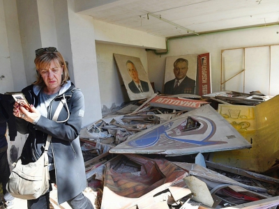 Un touriste prend des photos dans le Palais de la Culture dans la ville fantôme de Pripiat pendant une visite dans la zone d'exclusion autour de la centrale de Tchernobyl le 23 avril 2018 - Sergei SUPINSKY [AFP]