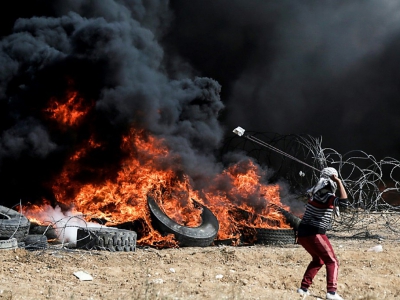 Un manifestant palestinien utilise un lance-pierre lors d'affrontements avec les forces israéliennes à l'est de Gaza, à la frontière avec Israël le 27 avril 2018 - MAHMUD HAMS [AFP]
