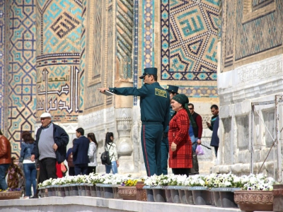 Des membres de la nouvelle "Police des touristes" renseignent des visiteurs de la ville de Samarcande, le 28 mars 2018 en Ouzbékistan - STR [AFP]